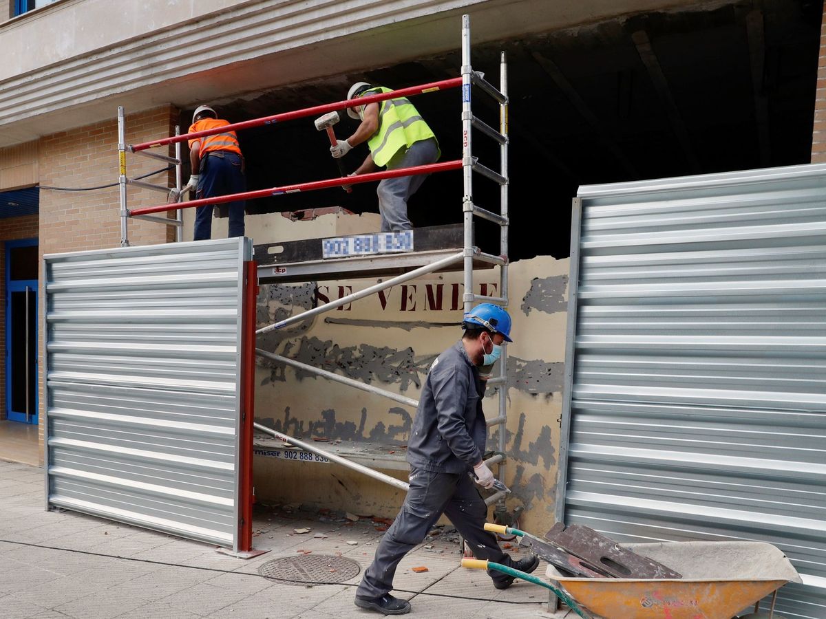 Foto: Obreros trabajan este lunes en la reforma de un bajo comercial en Oviedo. Foto: Efe