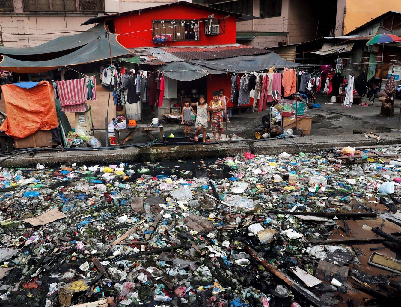 Un grupo de niños junto a un canal repleto de basura en Manila (FIlipinas) (EFE)
