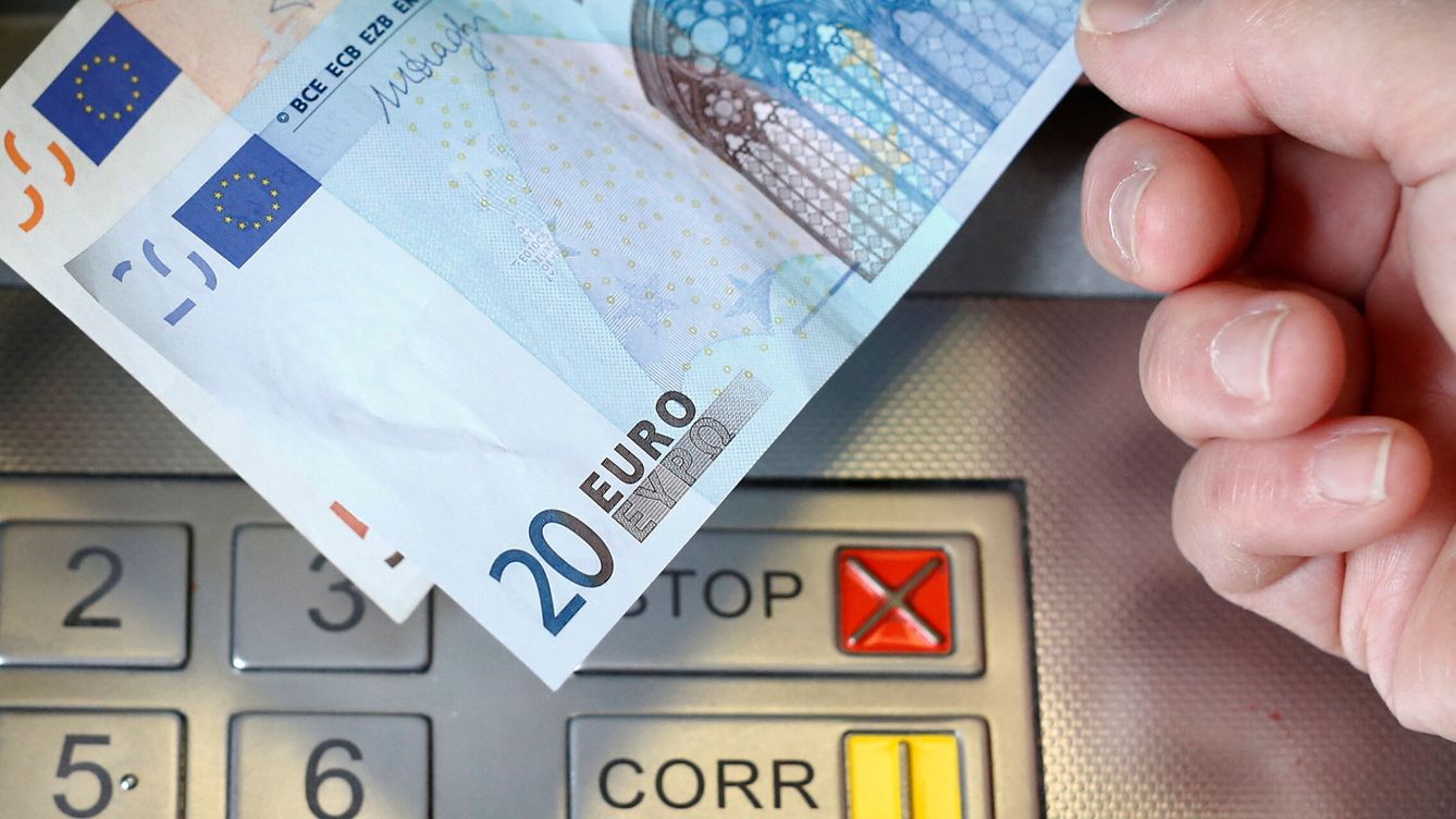 Foto: Una mujer saca un billete de 20 y otro de 50 euros de un cajero (Reuters / Thomas Hodel)