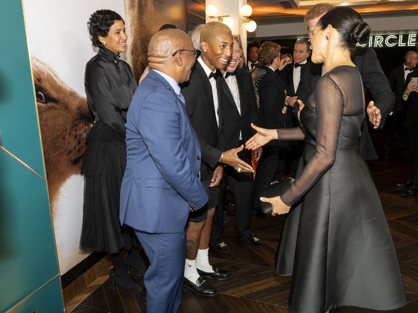Meghan Markle saluda a Pharrell Williams en el estreno de 'El Rey León'. (Reuters)