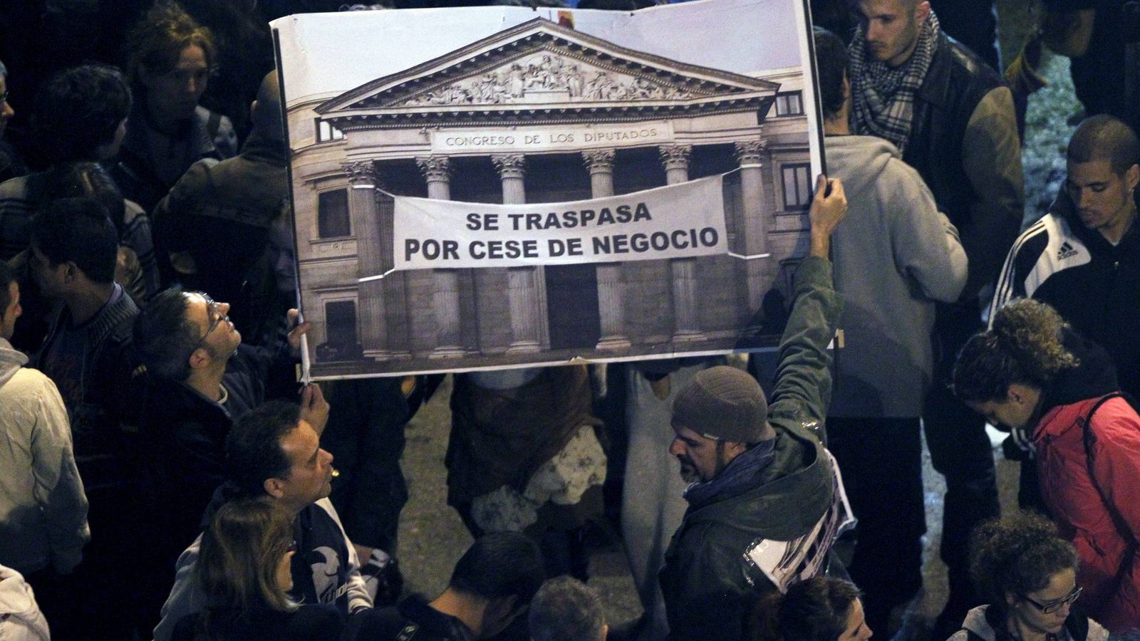 Foto: Varias personas sostienen una pancarta esta tarde en la plaza de Neptuno de Madrid, convocadas por la Coordinadora 25-S dentro de la iniciativa Rodea el Congreso. (EFE)