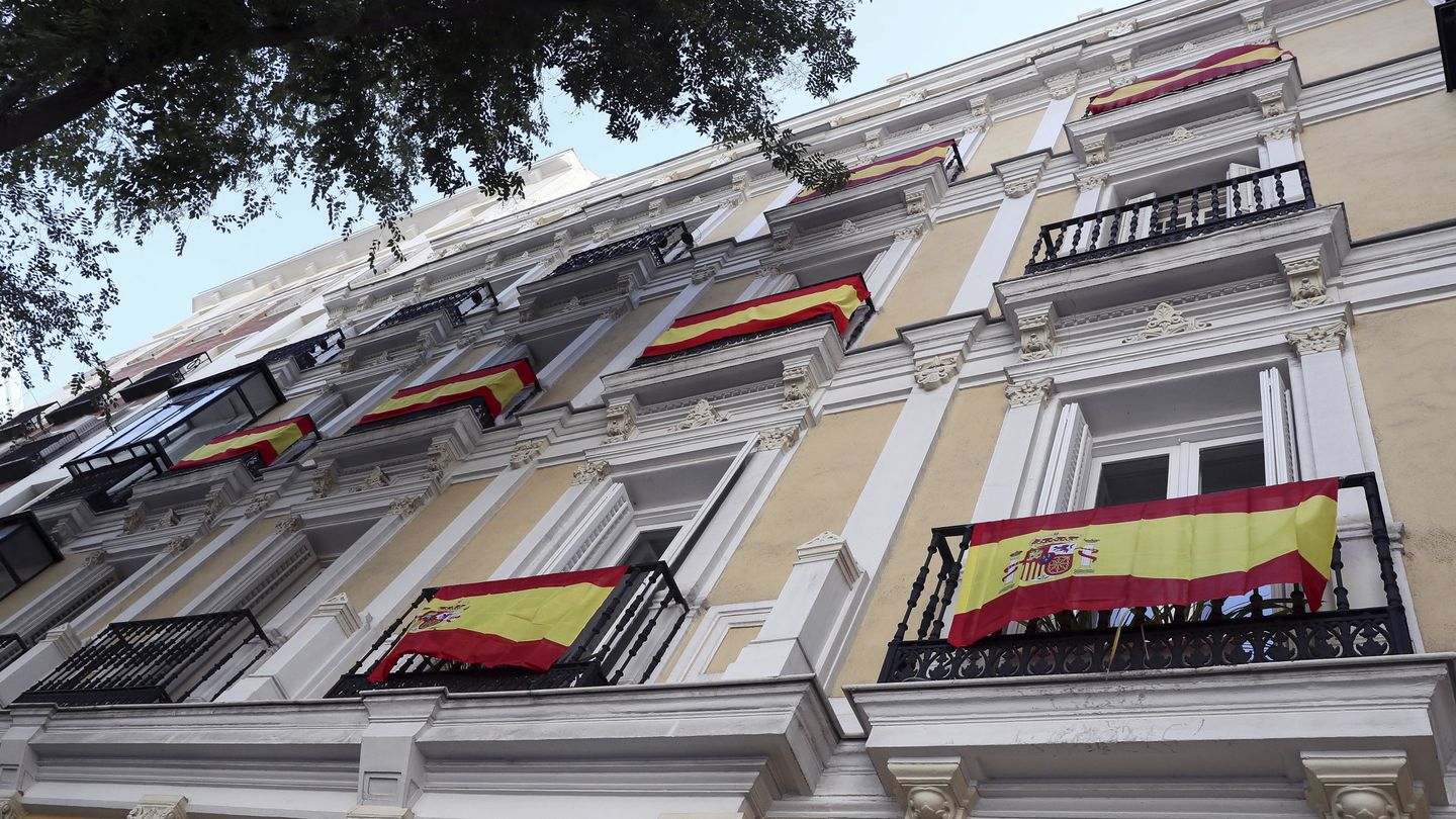 Algunas banderas de España lucen en balcones de la calle Almagro de Madrid. (EFE)