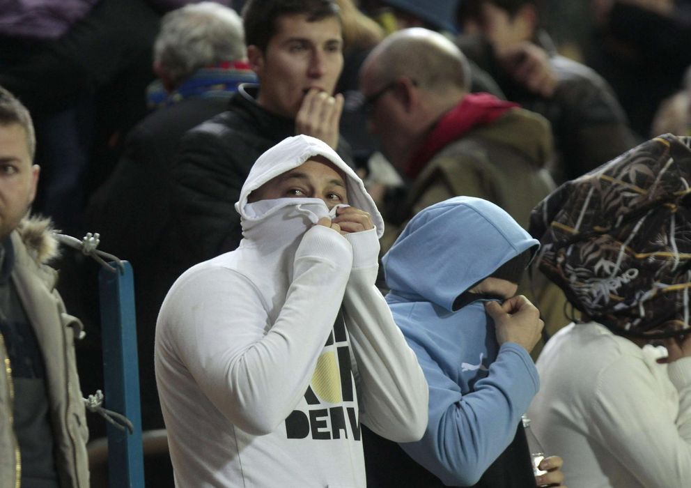 Foto: Aficionados de El Madrigal se tapan la cara para evitar inhalar los gases tras el lanzamiento de la bomba.