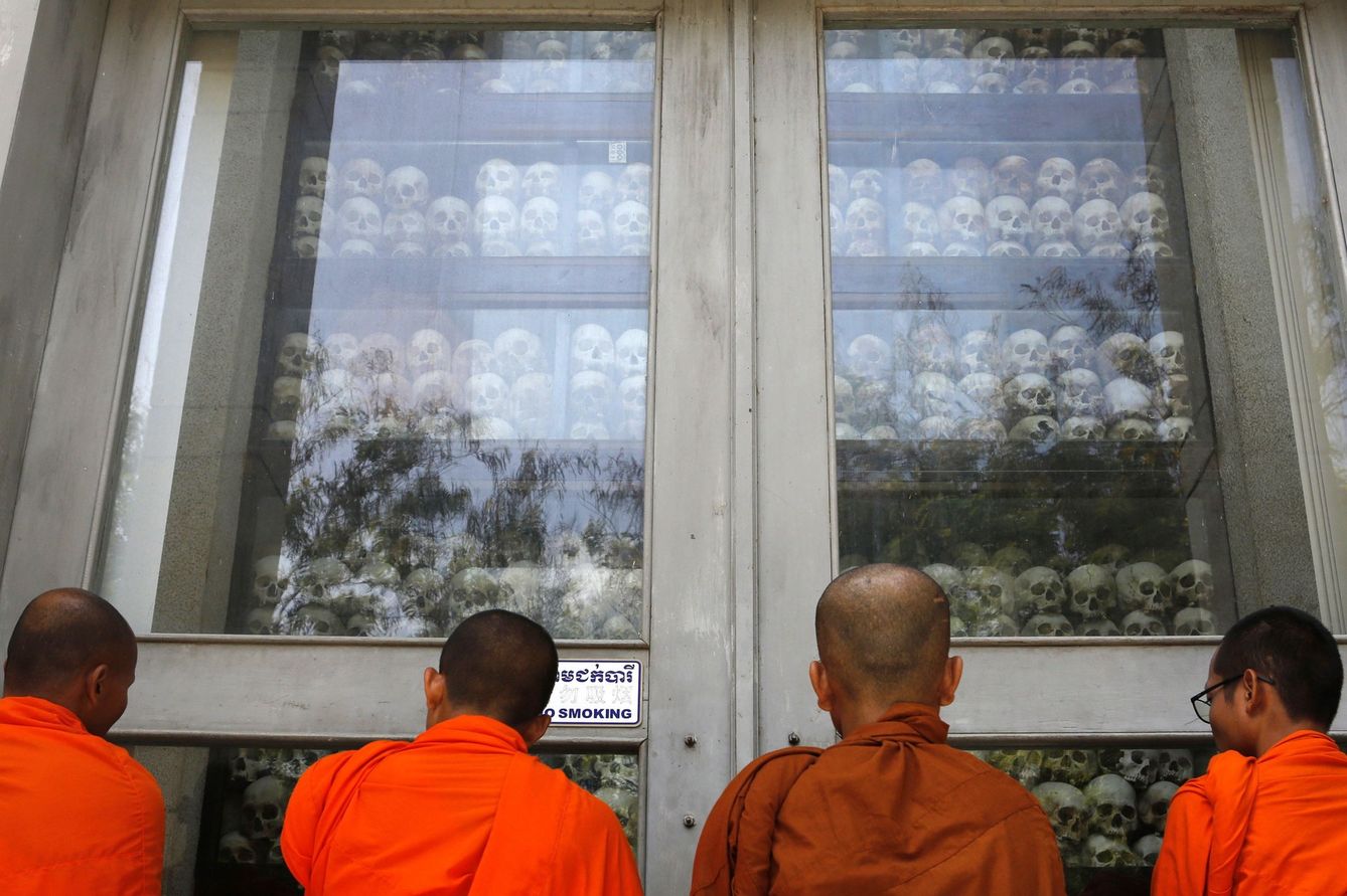 Monjes budistas observan los cráneos de víctimas encontrados en el área de exterminio de Choeung Ek, hoy convertido en un memorial del genocidio a las afueras de Phnom Penh. (Reuters)