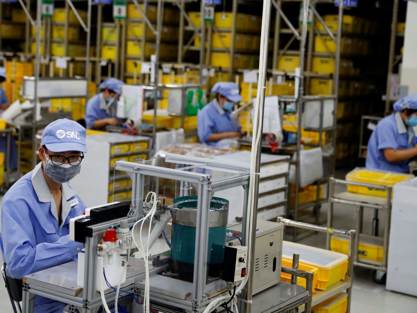 Trabajadores con mascarilla en una fábrica en China. (Reuters)