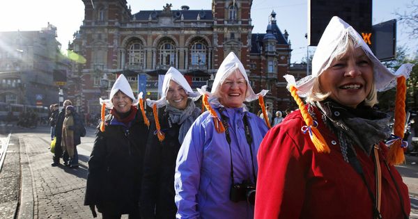 Foto: Turistas estadounidenses posan en Ámsterdam con sombreros típicos de agricultores. (Reuters)
