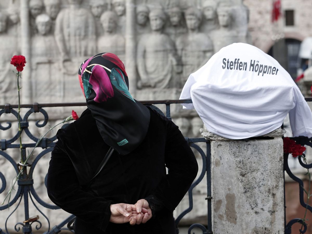 Foto: Una mujer deposita flores en la explanada de Sultanahmet, situada ante la mezquita azul en Estambul. (EFE / Sedat Suna)