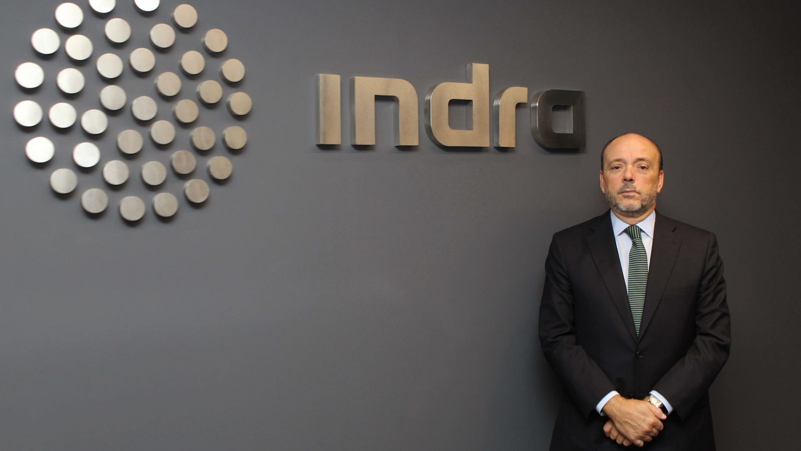 Foto: Javier Monzón posa junto al logo de Indra cuando era presidente de la multinacional. (EFE)