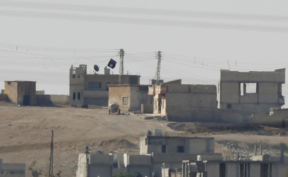 La bandera negra del Estado Islámico en el interior de la ciudad de Kobani (Reuters).