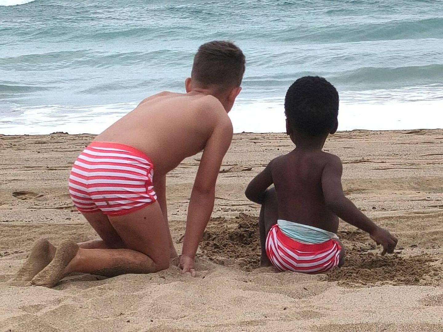 Dos menores frente a la playa. (Cedida)