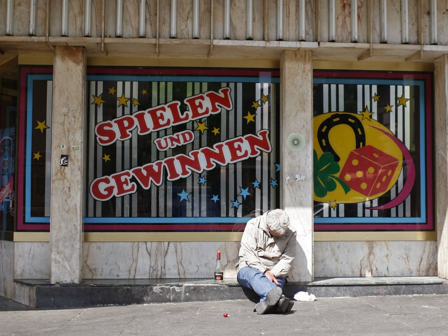 Un hombre borracho sentado delante de una sala de apuestas en la Reeperbahn de Hamburgo, en 2009. (Reuters)