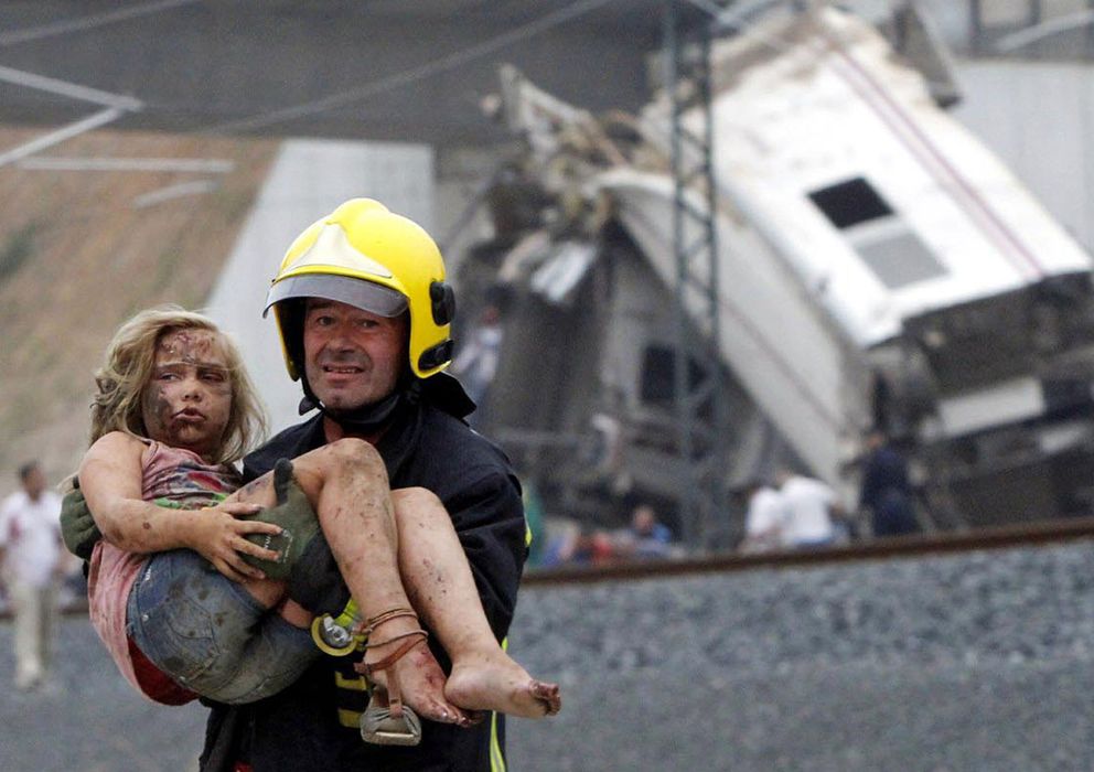 Foto: Un bombero aleja a una niña de la zona del accidente (Reuters)
