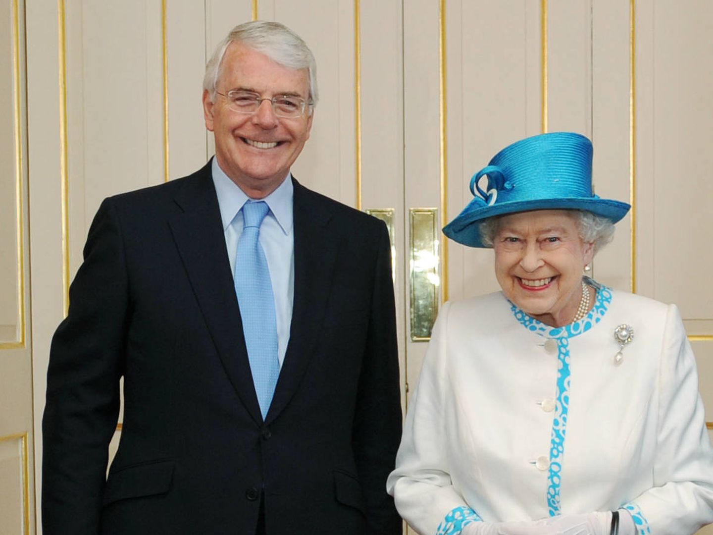 John Major, sonriente junto a la reina Isabel II. 