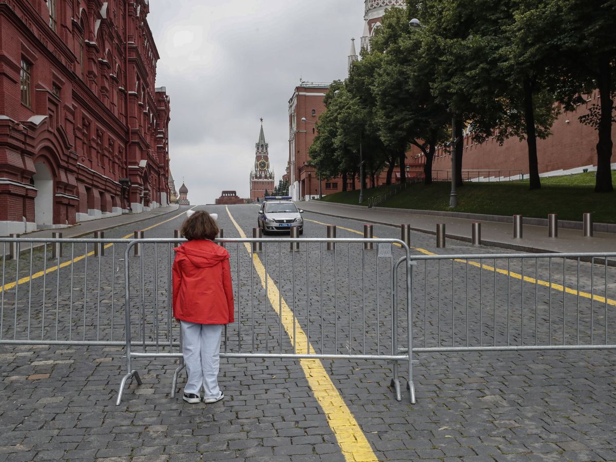 Foto: Una mujer, frente a una valla en la entrada cerrada de la Plaza Roja de Moscú. (EFE/Maxim Shipenkov)