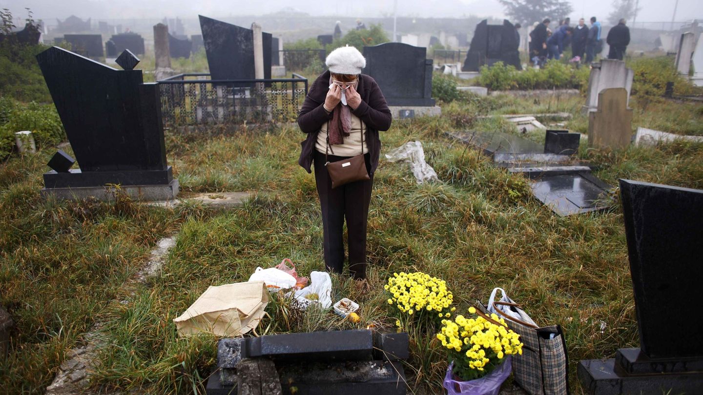 Una mujer serbokosovas llora ante una tumba profanada en Mitrovica (Reuters).