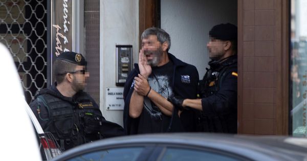 Foto: Agentes de la Guardia Civil acompañan a uno de los nueve detenidos durante el registro de un domicilio en Sabadell. (EFE)