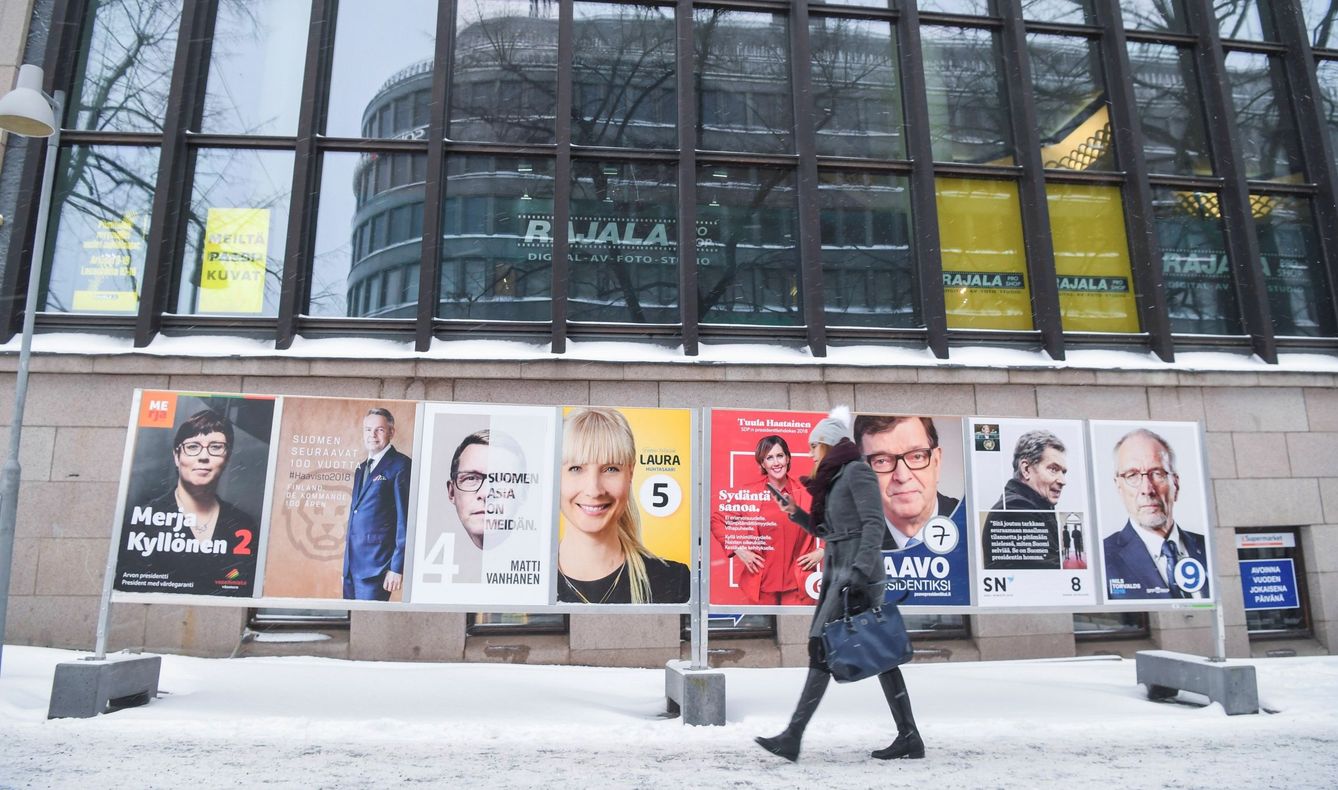 Una mujer camina junto a varios carteles electorales de los candidatos a las elecciones presidenciales finlandesas. (EFE)