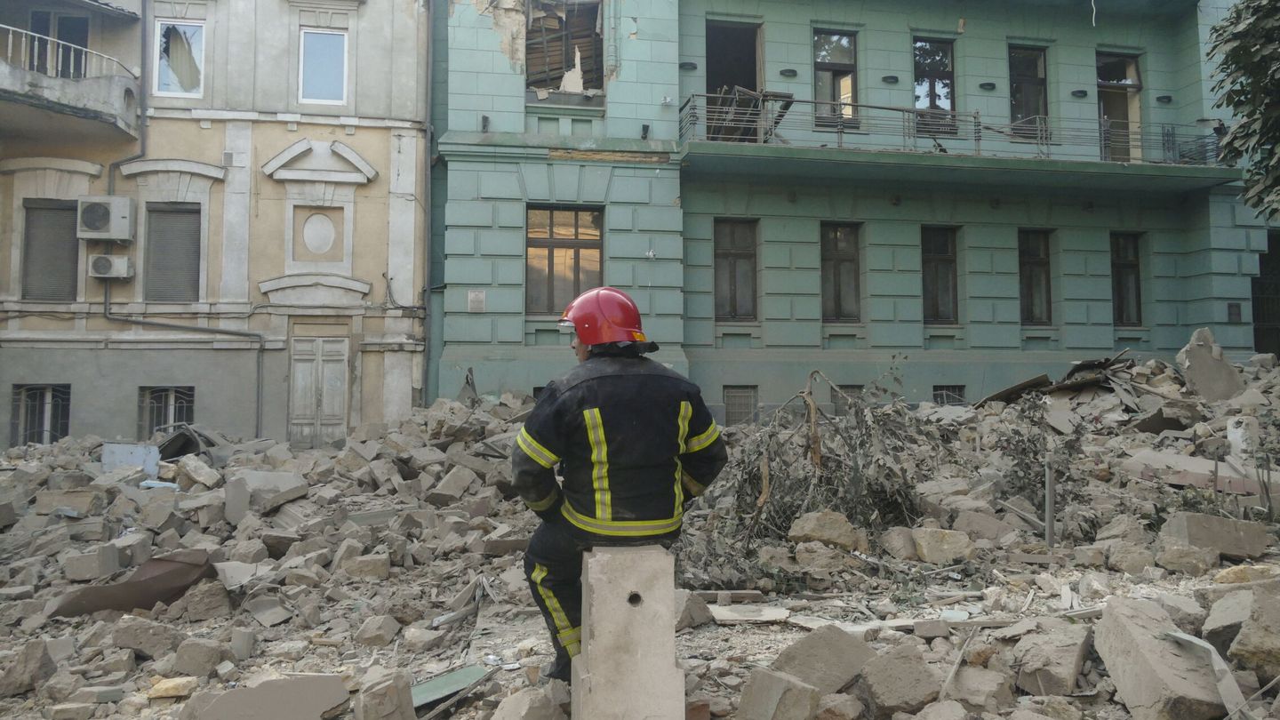 Un  miembro del equipo de rescate descansa cerca de un edificio residencial dañado por los bombardeos en Odesa, en el sur de Ucrania.  EFE/Igor Tkachenko 