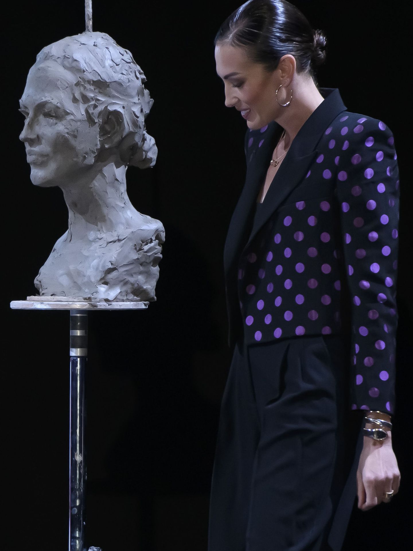 La modelo Nieves Álvarez, embajadora de 29ª Semana Internacional de la Moda Flamenca (SIMOF) 2024, observa el busto realizado de ella por el modelador onubense Martín Lagares. (EFE/Raúl Caro) 