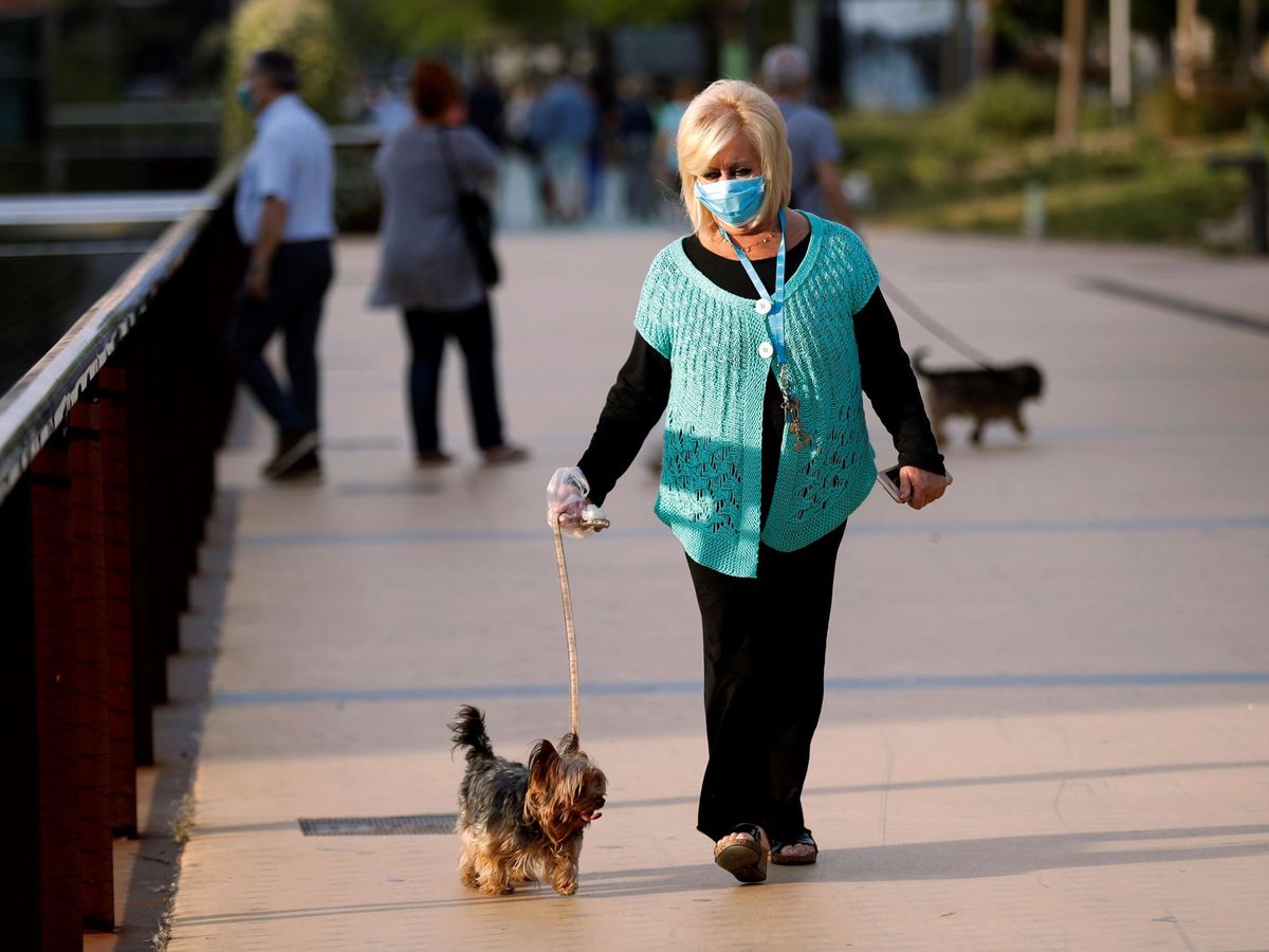 Foto: Una mujer pasea con su perro en Barcelona el pasado 7 de mayo. (EFE)