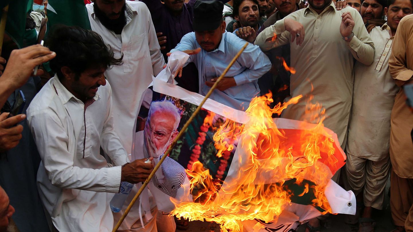 Refugiados afganos queman fotos de Narendra Modi durante una protesta contra India en Karachi, Pakistán. (EFE)