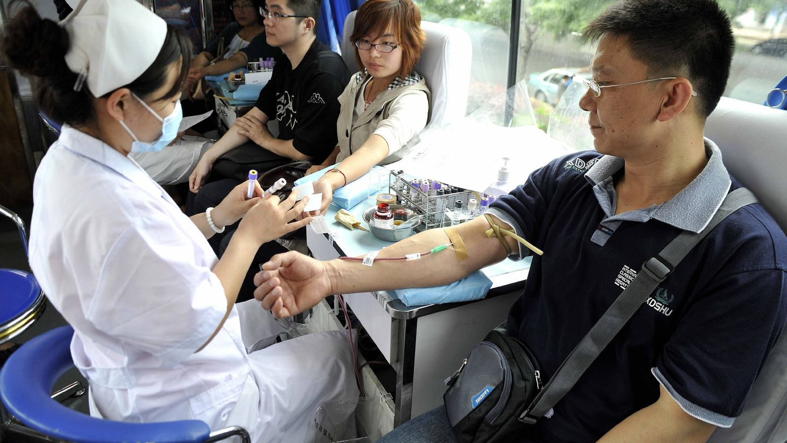 Foto: Varias personas donan sangre en un autobús móvil. (Efe) 