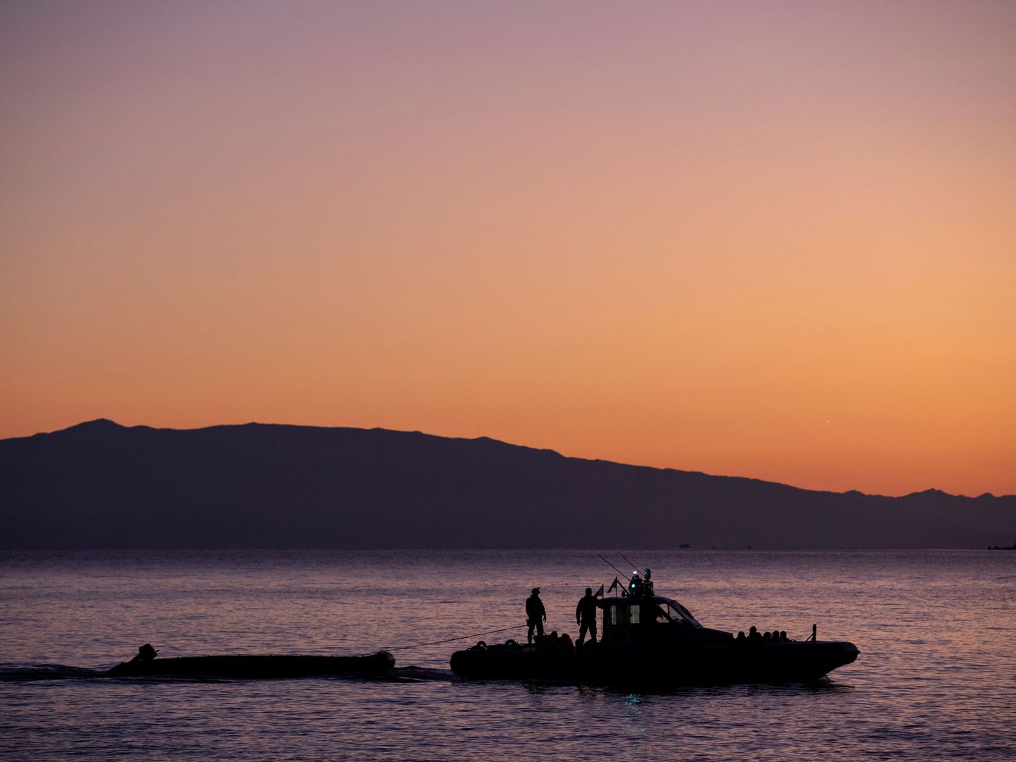Un barco de Frontex remolca una embarcación de migrantes. (Reuters)