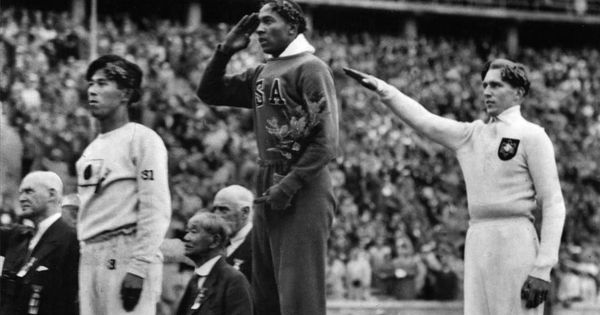Foto: El atleta estadounidense recibe la medalla de oro en los Juegos Olímpicos de Berlín de 1937. Tra él, un corredor alemán hace el saludo nazi.