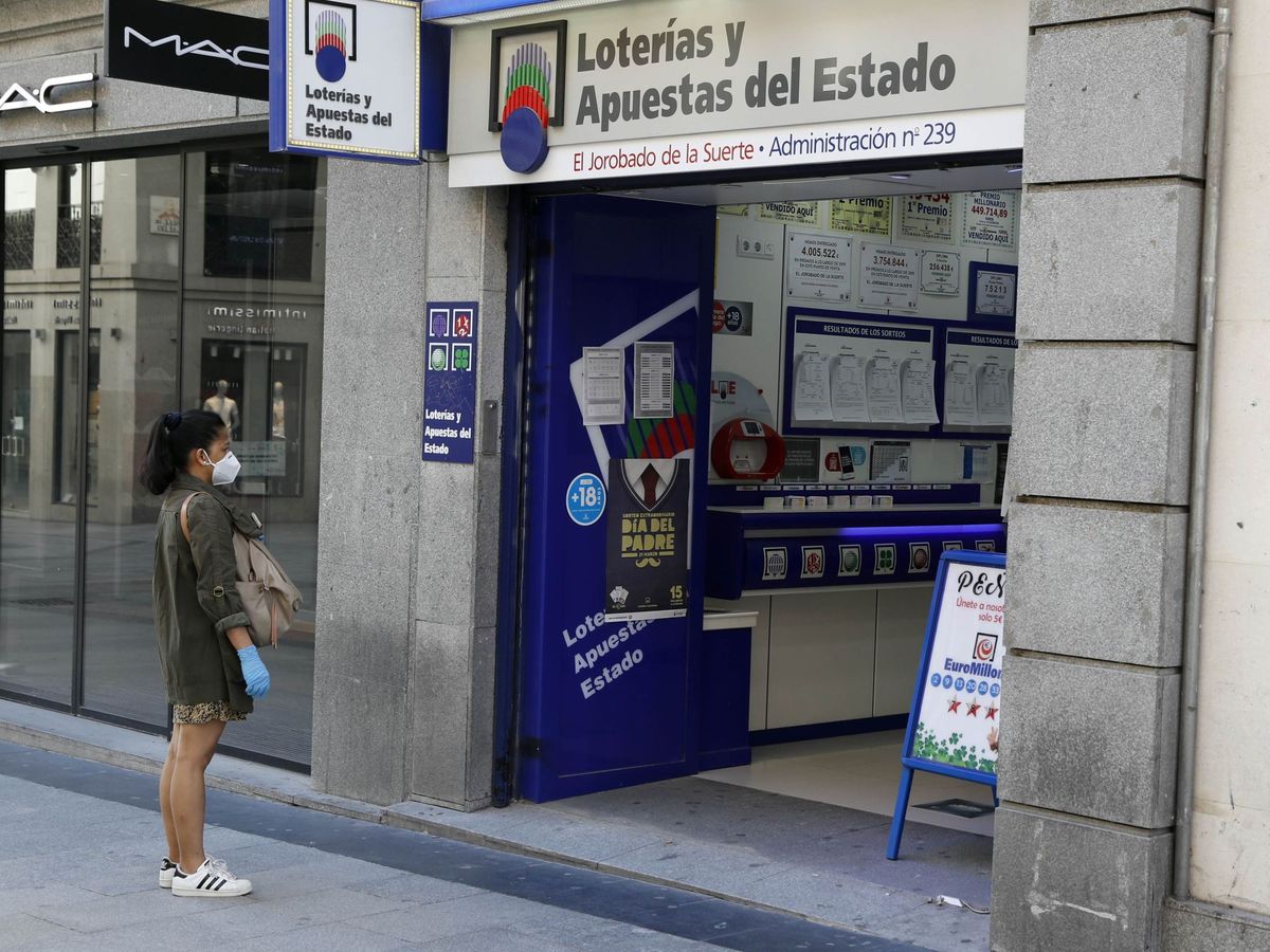 Foto: Foto de archivo de una mujer esperando para entrar en una administración de lotería de Madrid. (EFE)