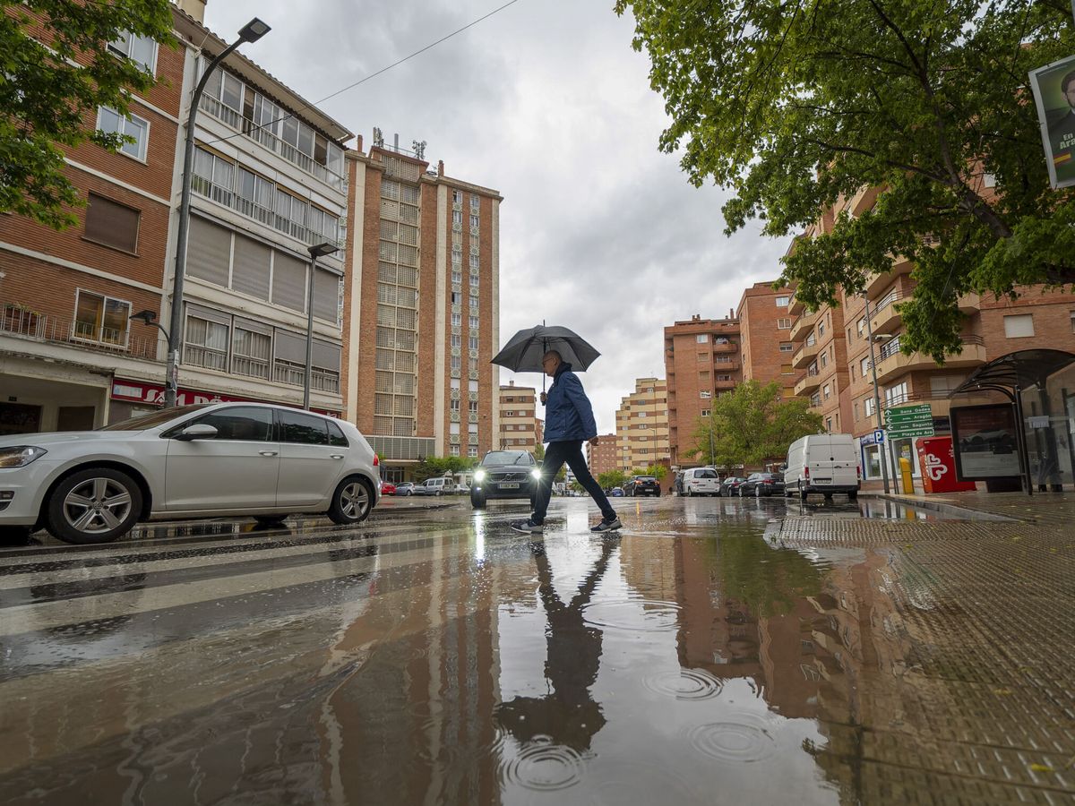 Foto: Un hombre se protege de la lluvia bajo un paraguas en Teruel. (EFE/Antonio García)