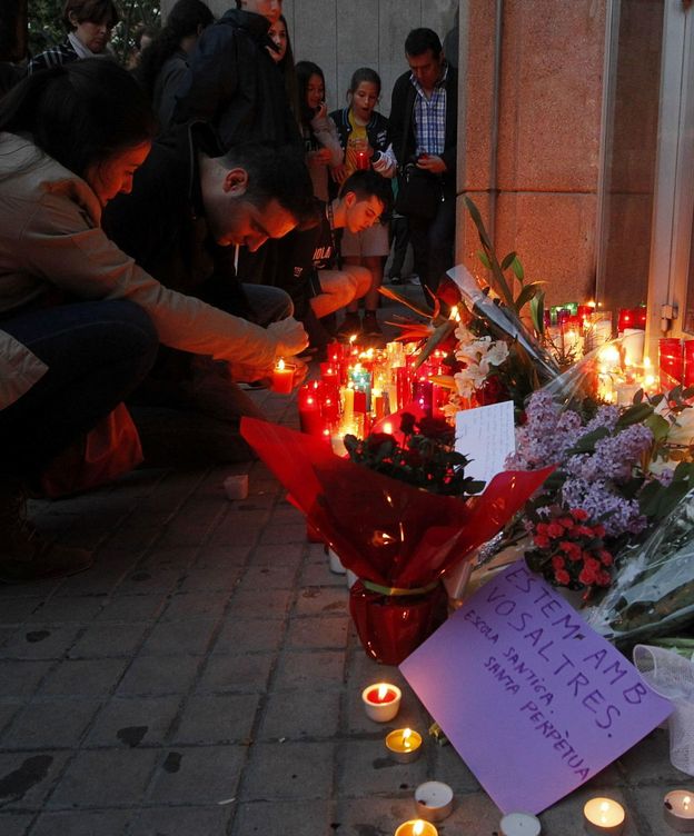 Foto: Varias personas depositan flores y velas a las puertas del Instituto de Educación Secundaria Joan Fuster en recuerdo del docente asesinado (EFE)