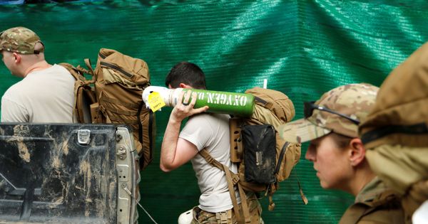 Foto: Militares estadounidenses cargan cilindros de oxígenos hacia la gruta Tham Luang. (Reuters)
