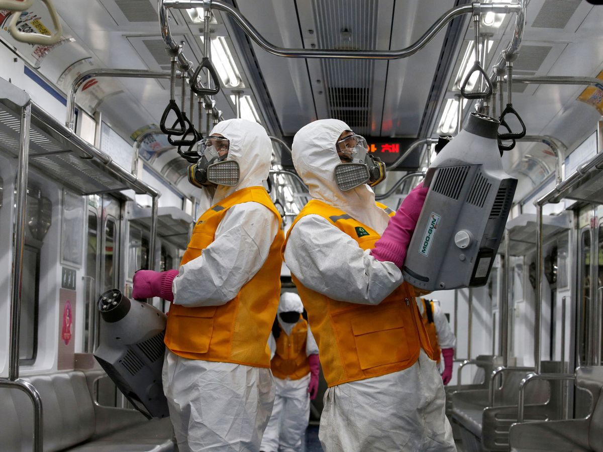 Foto: Dos empleados de una empresa de desinfección en Corea del Sur. (Reuters)