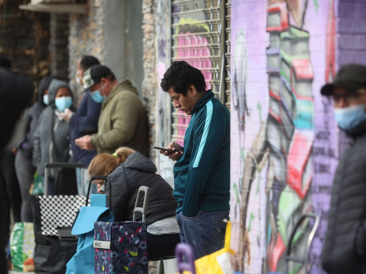 Foto: Vecinos de Aluche, Madrid, hacen cola para recoger alimentos (EFE)