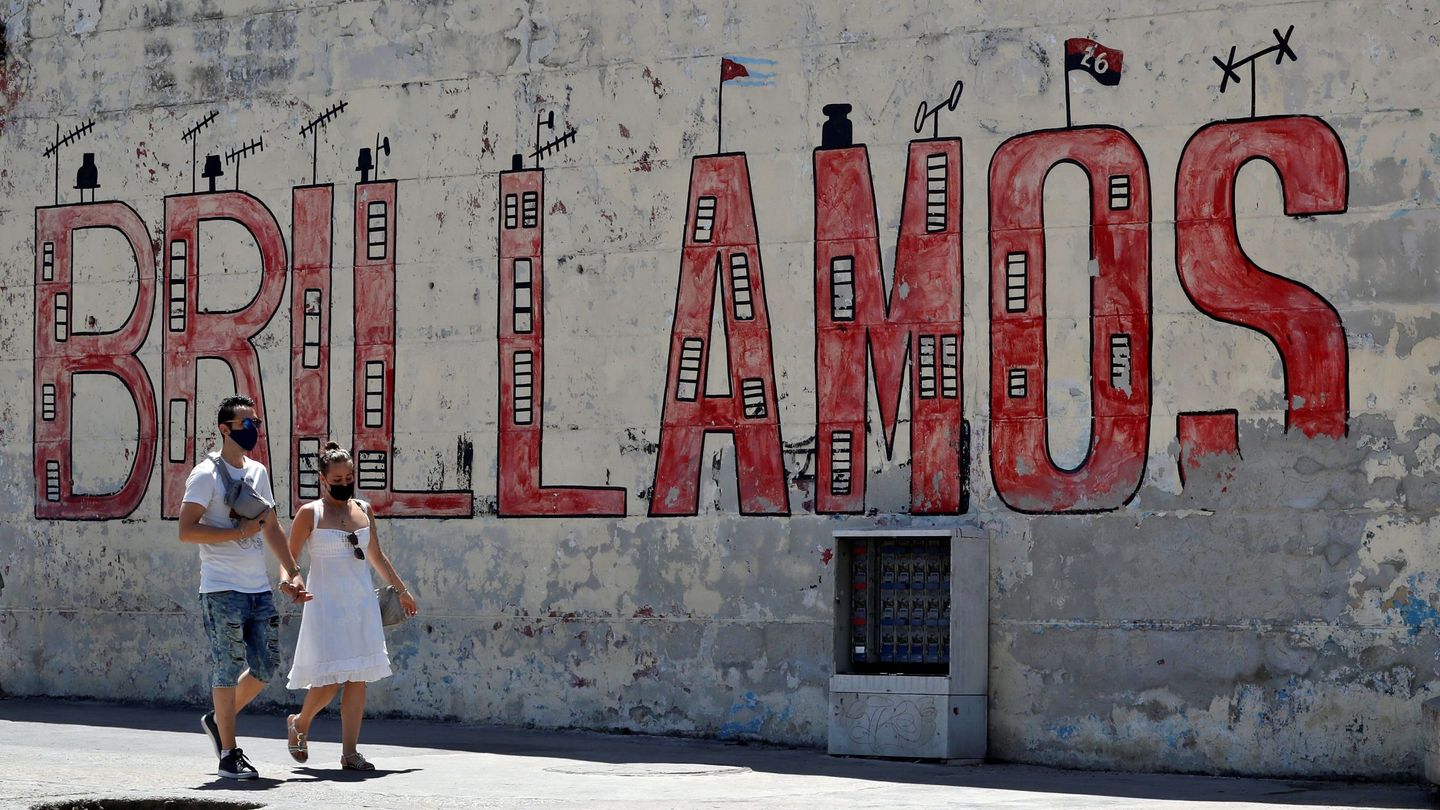 Una pareja pasa frente a un mural en apoyo a la revolución en La Habana (EFE)