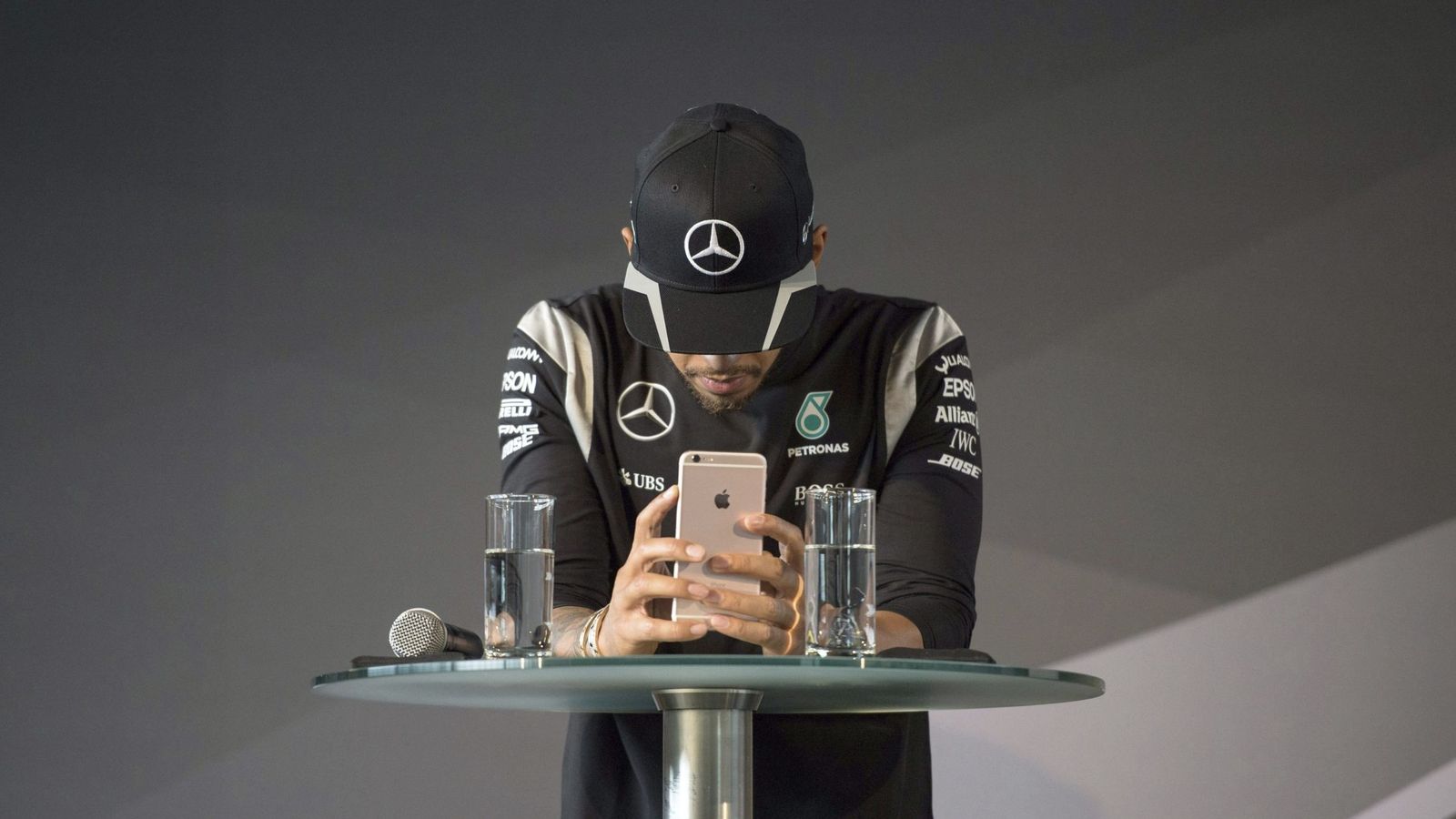 Foto: Lewis Hamilton con su teléfono móvil antes de una rueda de prensa.