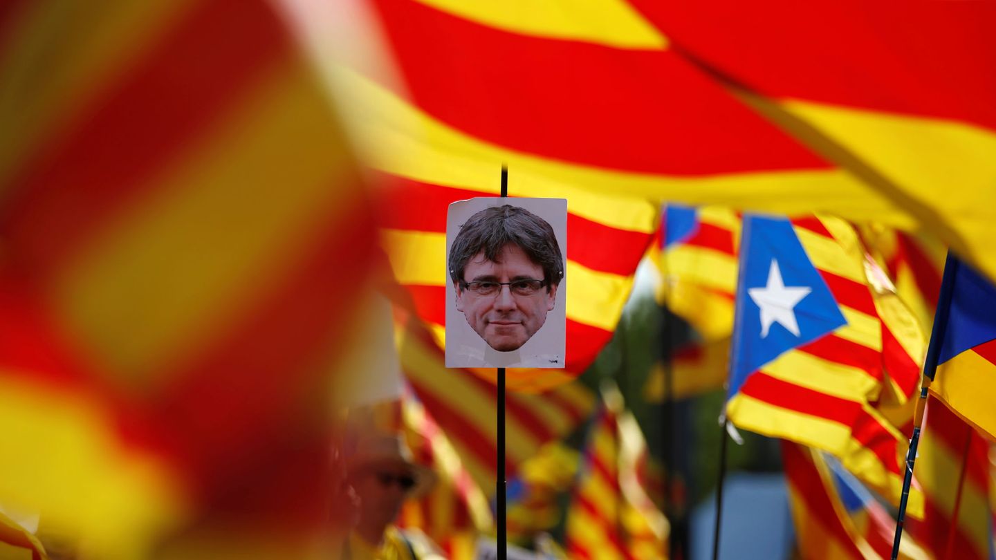 Manifestantes con pancartas del expresidente de la Generalitat, Carles Puigdemont. (Reuters)