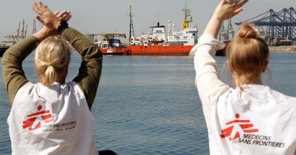 Foto: Dos miembros de Médicos sin fronteras dan la bienvenida al Aquarius en el puerto de Valencia. (EFE)