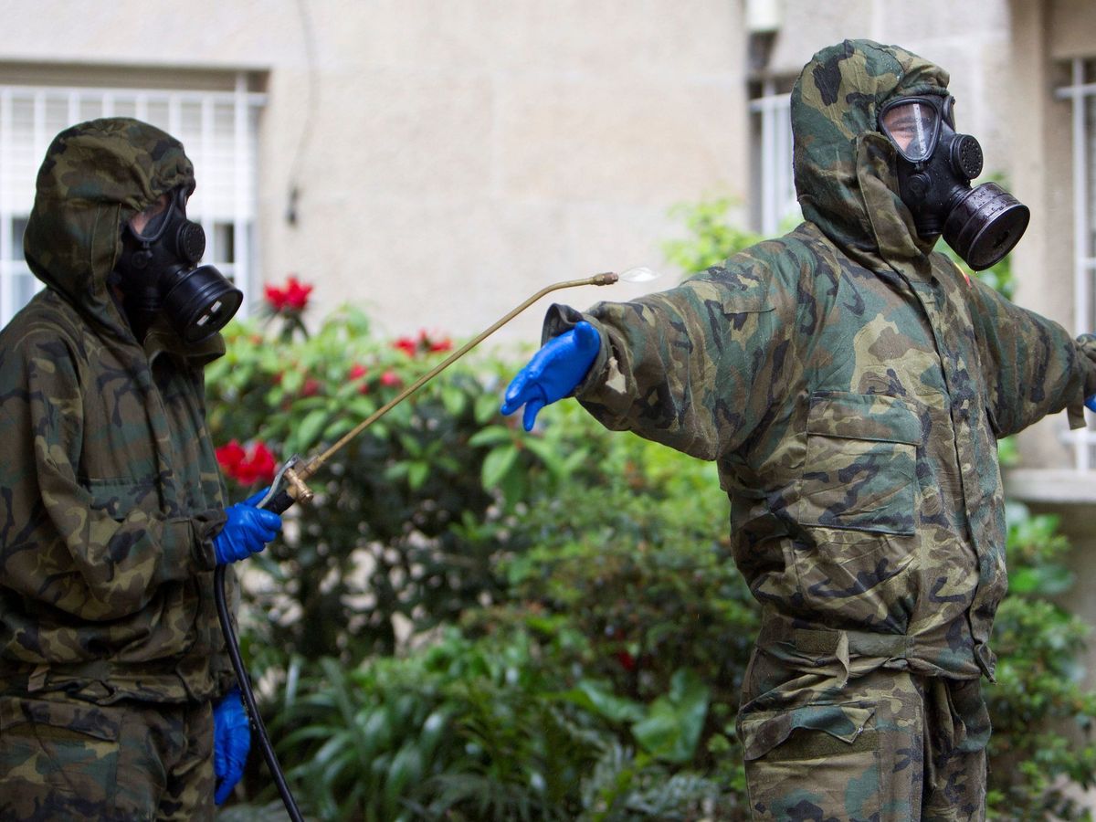 Foto: Miembros del Regimiento Zamora de la Brilat se desinfectan tras efectuar la desinfección de la Residencia de Las Angélicas de Vigo. (EFE)