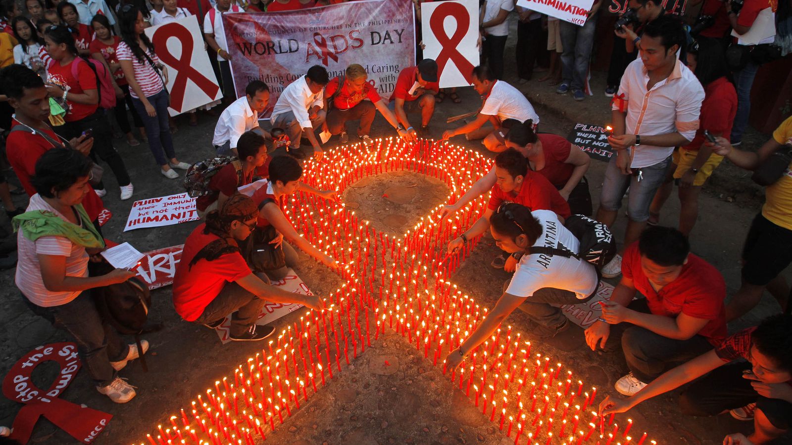 Foto: Un grupo de enfermos de sida filipinos, y sus familiares, encienden velas en contra de la enfermedad. (Reuters)