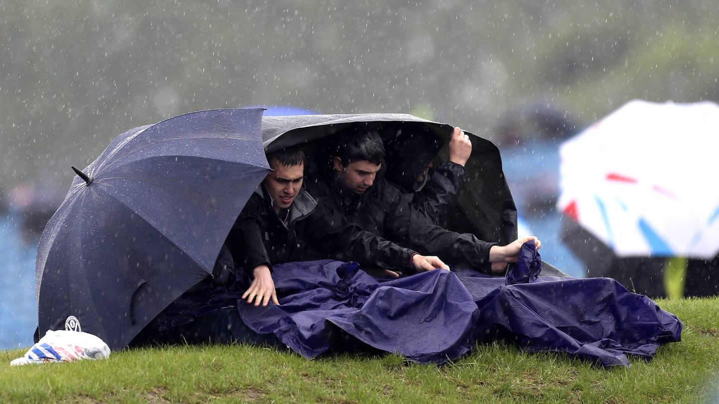 La lluvia puso las cosas difíciles a los aficionados. (EFE/Valdrin Xhemaj)