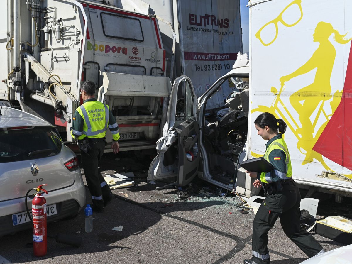 Foto: Dos agentes de la Guardia Civil inspeccionan los vehículos implicados. (EFE/Andreu Esteban)
