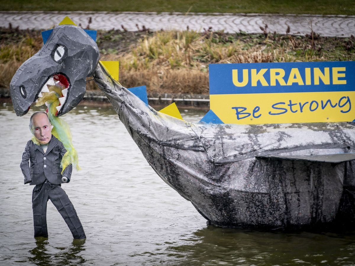 Foto: Una obra de arte representando un dragón comiéndose al presidente de Rusia, Vladímir Putin, con el cartel 'Ucrania, sé fuerte' flota en un embalse en Helsinge, Dinamarca. (EFE/Claus Rasmussen)