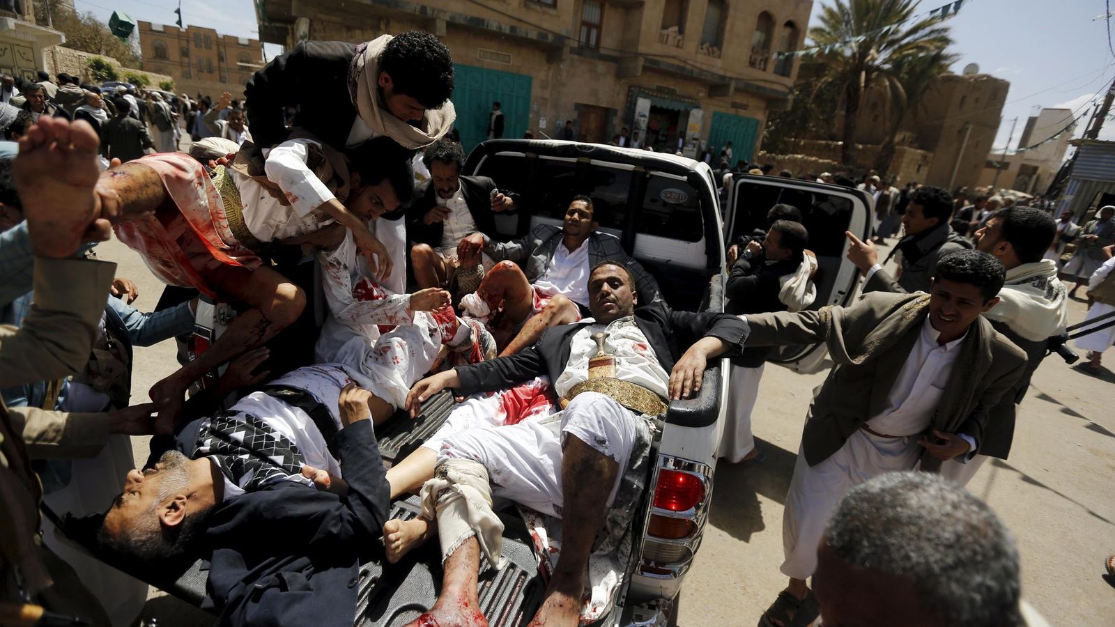 Foto: Injured people are carried onto a truck to be rushed to a hospital after a suicide bomb attack at a mosque in sanaa