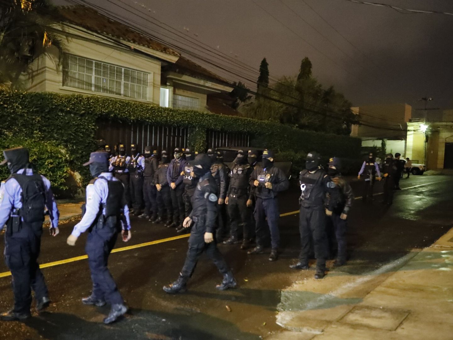 Agentes policiales rodean la residencia del expresidente hondureño en Tegucigalpa (Honduras). (EFE/Gustavo Amador)