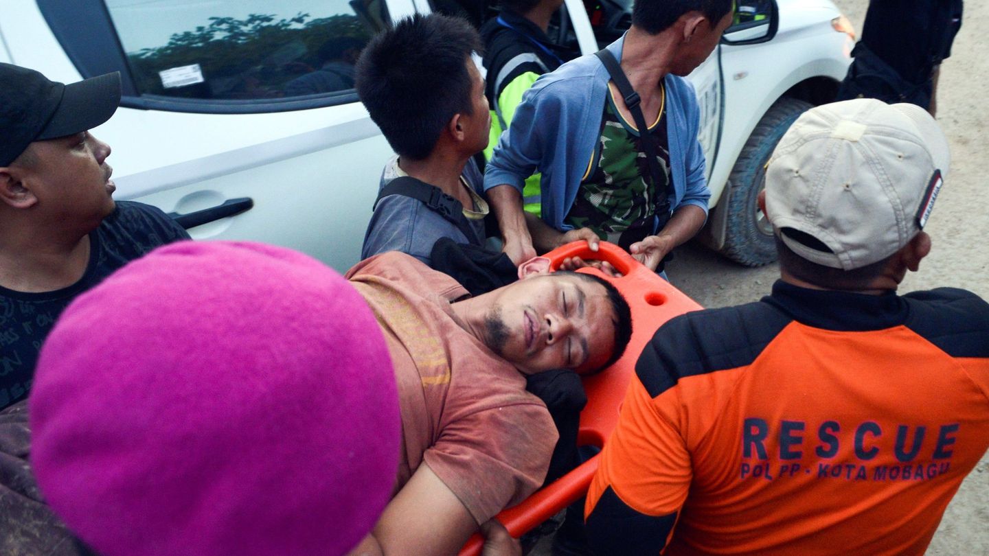 Escatistas indonesios llevan a un sobreviviente. (EFE)