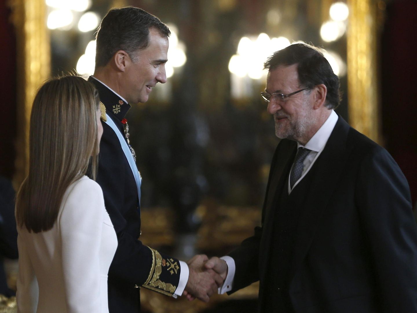 Los reyes Felipe VI y Letizia saludan al ahora expresidente del Gobierno, Mariano Rajoy, en la recepción a los representantes institucionales en el Palacio Real. (EFE) 