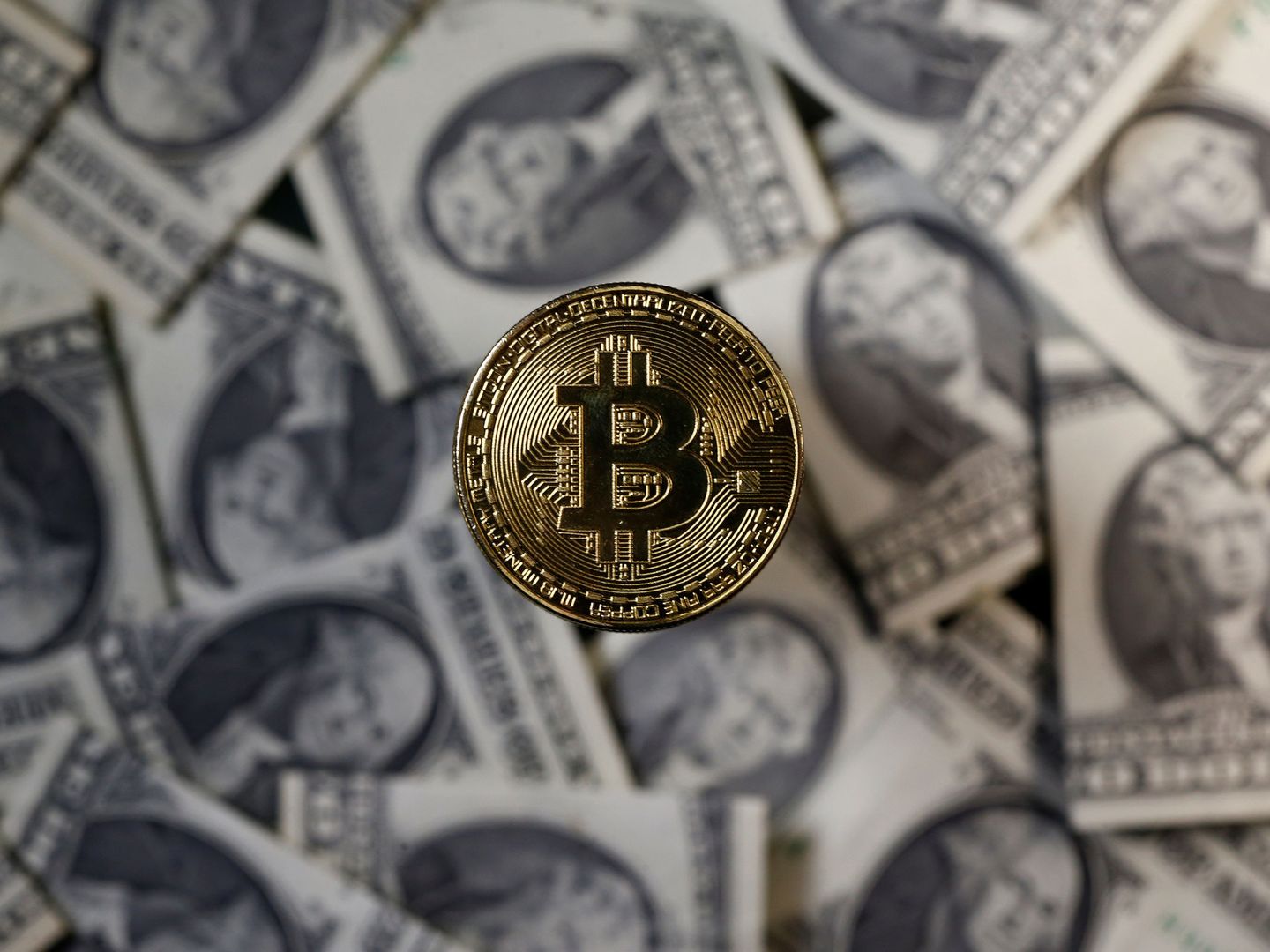 A bitcoin (virtual currency) coin placed on Dollar banknotes is seen in this illustration picture, November 6, 2017. REUTERS Dado Ruvic Illustration