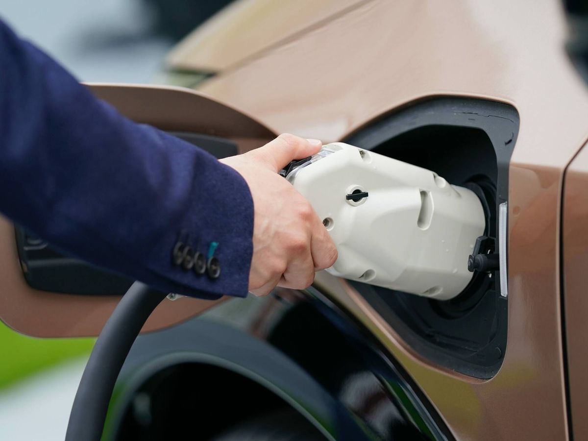 Foto: Un conductor conecta el cable de recarga a su vehículo eléctrico. (Nissan)