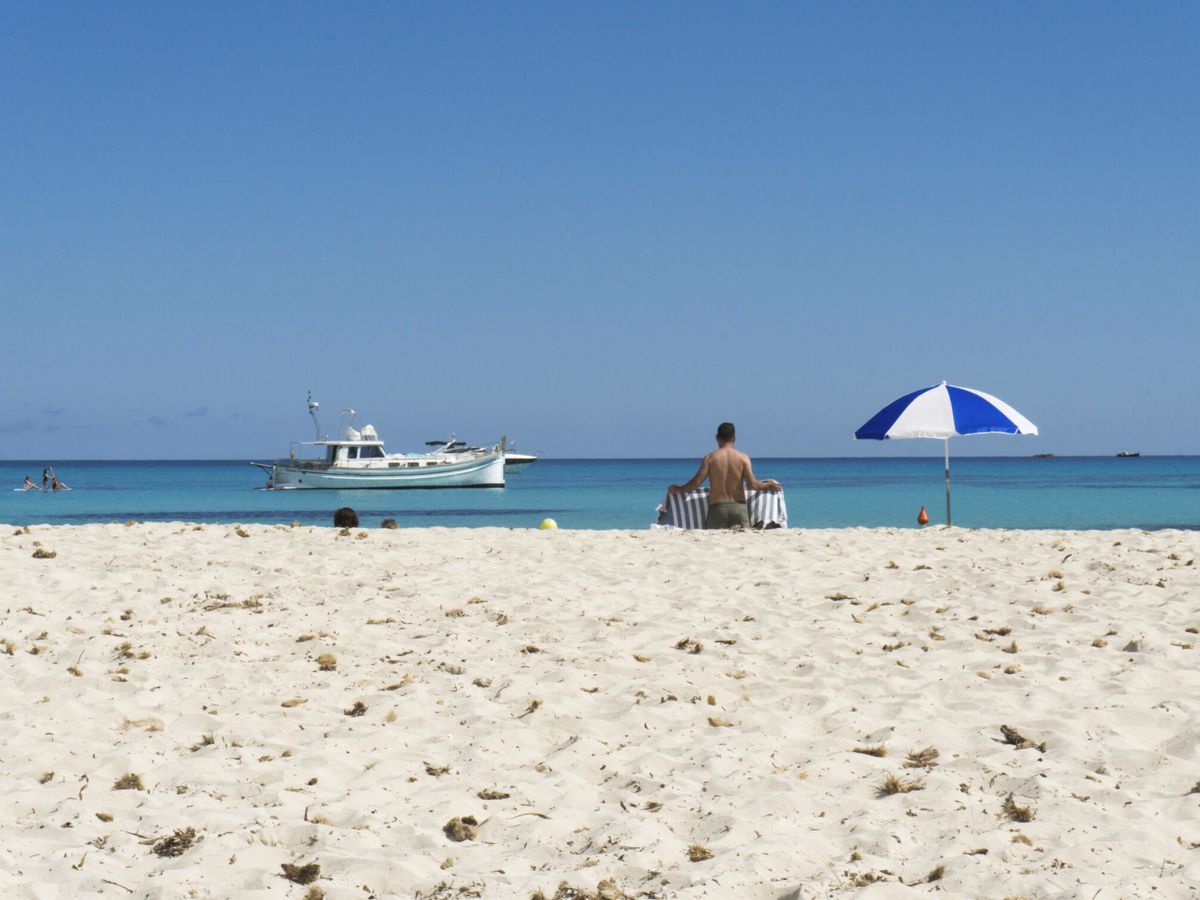 Foto: Un hombre en la playa de Punta Prima, en Menorca. (EFE/David Arquimbau Sintes)